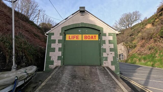 Slow tilt up: Life boat garage with ramp at Tramore sea coast, Ireland
