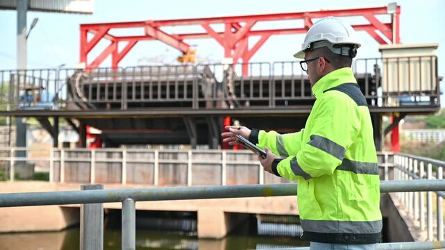 A specialist engineer is inspecting the operation of a water filter in a wastewater treatment plant.