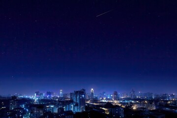 Fototapeta premium City skyline at night with twinkling stars and a shooting star in a deep blue sky