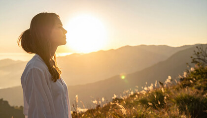 Serene woman stands in profile against sunset backdrop, embodying peace and emotional healing in nature embrace