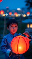 Young Asian Boy in Traditional Attire Holding Illuminated Lantern at Night
