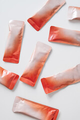 Many small red and white sealed plastic sachets with powder.
