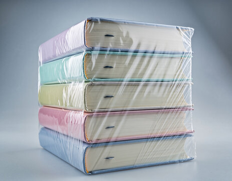 Stack of New Pastel Hardcover Books Wrapped in Protective Plastic