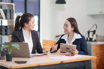 Asian businesswoman sitting at work using laptop talking and consulting in office	