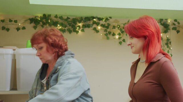 caucasian women at pantry share moment as older coordinator reviews inventory while younger shopper holds bananas subtle eye contact and reassurance, gentle conversation about needs, compassionate