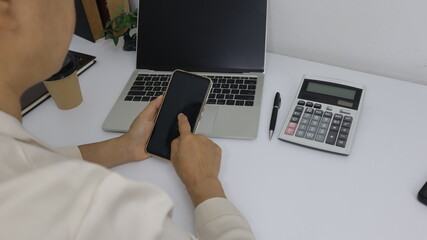 business hands searching for data on Mobile Phone with analyzing charts at his workplace.