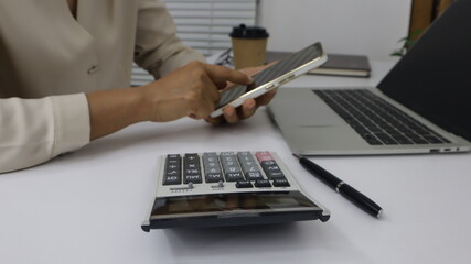 business hands searching for data on Mobile Phone with analyzing charts at his workplace.