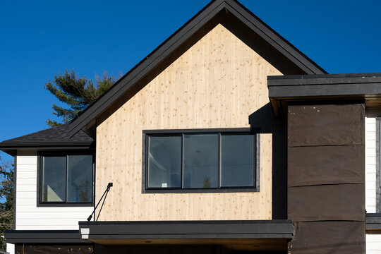 New house under construction, wood panel exterior, black moisture barrier, investment real estate and finance, housing supply background
