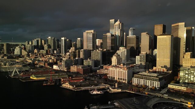 Sideways Strafing Drone Flight Across Seattle Downtown Skyline and Waterfront Beneath Dramatic Storm Clouds
