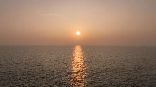 Sunset over the Konkan coast, golden sunlight reflecting on calm sea waves, aerial view of western India&rsquo;s scenic coastal landscape, peaceful evening, serene horizon