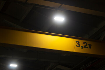 LED lighting projector in a dark production workshop, ventilation devices, windows and concrete structures