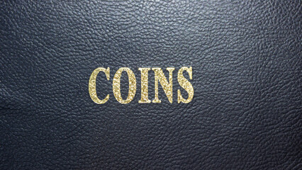 Coins with gold lettering on a black leather base