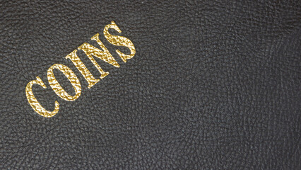 Coins with gold lettering on a black leather base