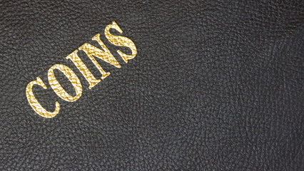 Coins with gold lettering on a black leather base