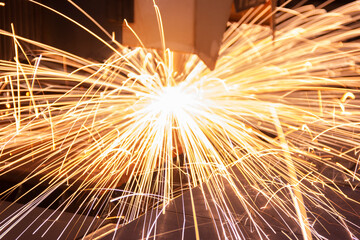 Cutting metal with a laser machine, the laser head cuts the metal, sparks fly when it comes into contact with the surface