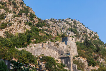 Montenegro, Kotor. Rugged mountain fortress ruins cling to a rocky hillside