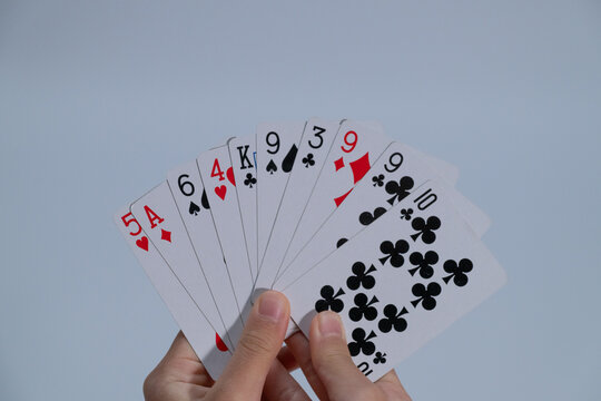 Close up of hands holding a fan of playing cards with copy space