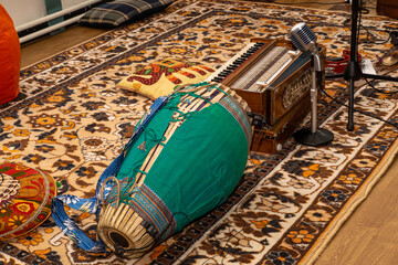 Fototapeta premium Everythings snug: big drum on rug, wooden box with keys, retro mic, soft pillows - perfect for sitting down and making gentle spiritual sounds with selective focus