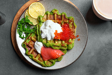 Healthy low carb breakfast with green spinach waffles, salmon, red caviar, ricotta cheese