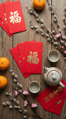 Celebrating chinese new year with traditional tea oranges and red envelopes cozy indoor setting vibrant cultural atmosphere