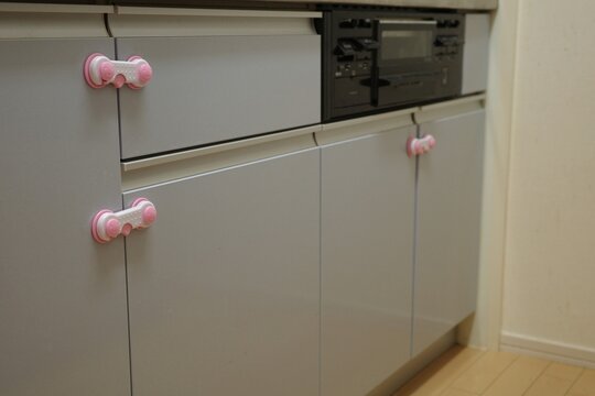 Child proof safety locks installed on kitchen cabinet doors and drawers.