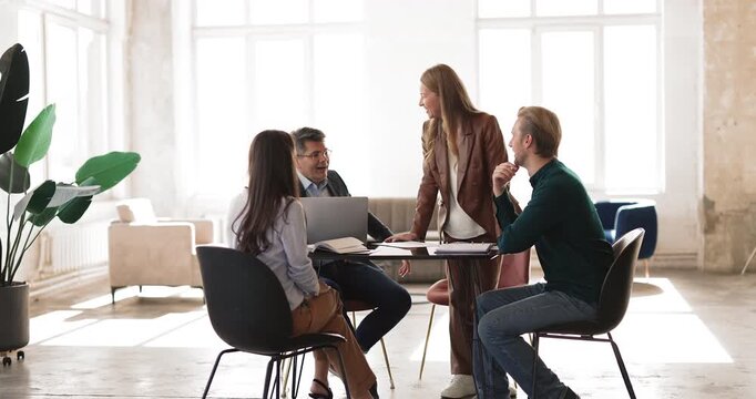 Office employees engaging in collaborative team meeting, discussing business or marketing strategy, sharing idea, reviewing project details, planning upcoming tasks gather together in modern workspace