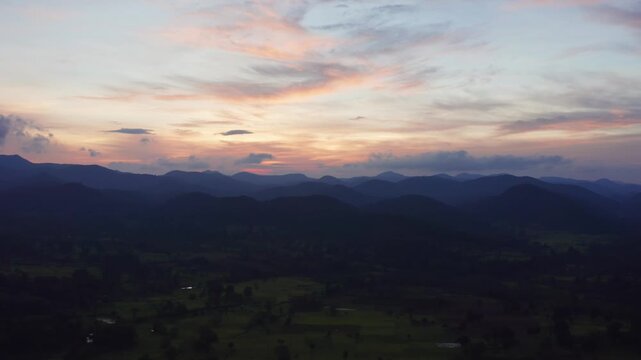 Stunning aerial sunset bathes layered Eastern Ghats hills in orange pink hues over dark green valleys near Daringbadi the Kashmir of Odisha hill station.