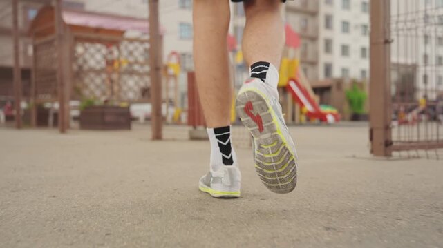 closeup sneaker walk urban playground showing patterned socks and worn sole, lowangle heel strike and tread detail on asphalt, precise gait and tempo highlighting training form and grip, subtle
