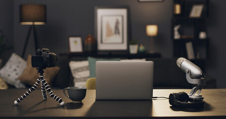 Empty room, laptop and microphone for content creation in home, camera and diy recording studio in lounge. Tech, computer and headphones for podcast production, social media and gear at apartment © Kobus Louw/peopleimages.com