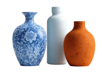 Trio of vases blue floral, pale speckled, and orange terracotta, lit against dark