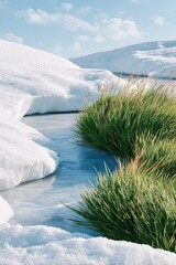 Obraz premium Snowy field with melting ice and lush grass along a blue stream under a bright sky