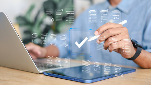 Business professional approving digital documents with checkmark interface on tablet and laptop. Concept of workflow automation, document approval, digital process management and enterprise software.