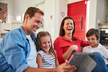 Obraz premium Laugh, family and children in home with tablet, smile and bonding together with online entertainment. Happy parents, house and siblings on sofa with comedy, tech or internet for movie or cartoon show