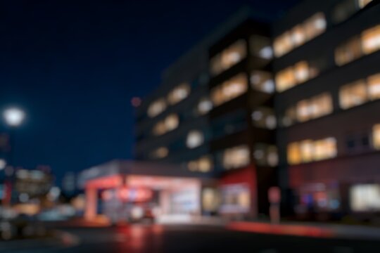 Blurry photo of a hospital with ambulances on standby at night