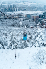 Tbilisi Aerial View with Blue Cable Car over Snowy Landscape