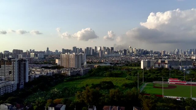 Dolly-In Landscape Aerial of BGC Taguig Metro Manila in the Distance with Trees in the Foreground