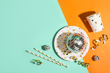 Composition with paper cup, plate and disco balls on color background
