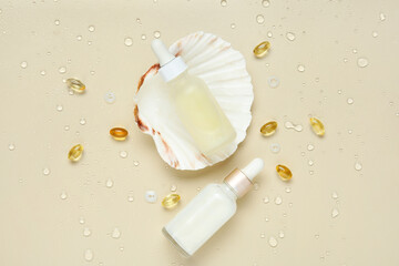 Naklejka premium Bottles of cosmetic products and pills with collagen on beige background with water drops