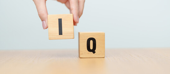 hand change wooden block from IQ to EQ, balance between intelligence quotient and emotional quotient, AQ Adversity, MQ, Moral, SQ and Social quotient concepts