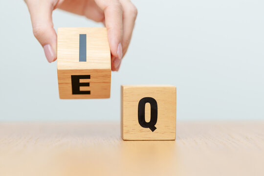 hand change wooden block from IQ to EQ, balance between intelligence quotient and emotional quotient, AQ Adversity, MQ, Moral, SQ and Social quotient concepts
