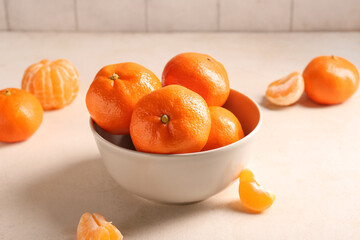 Bowl with sweet tangerines on white grunge background, closeup