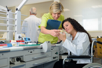Obraz premium dentist and nurse in wheelchair at work