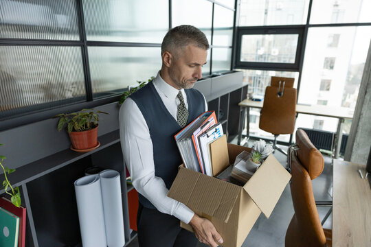 Resign and resignation. Change of job or fired from company resign. Losing his job. Jobless man unemployed. Career failure. Businessman leaving office holding box with office supplies