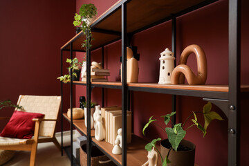Bookshelf with stylish decor and plants in room