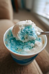 blue and white vanilla ice cream in a cup with a spoon