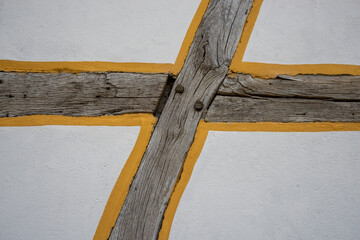 Weathered half-timbered farmhouse wall with yellow detail