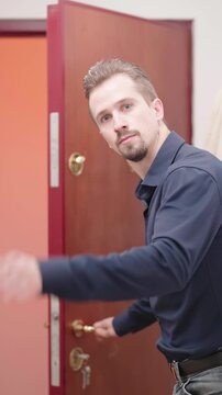 Man in elegant shirt at home open the door and show way out funny gesture