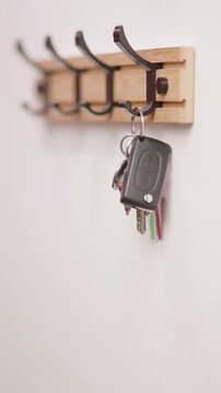Person hand hang car key on hook