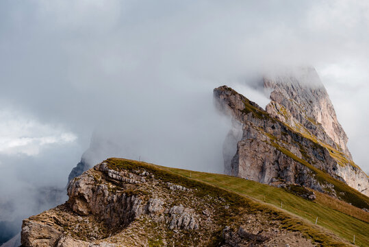 Seceda mountain ridge in the Dolomites shrouded in clouds and mist