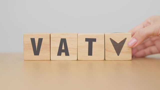 hand change wooden block with VAT text to UP and Down arrow icon. Value Added Tax, decrease and Increase, Taxpayer, Taxable Income, Tax Filing, Deduction, Withholding Tax,  Computation and Exemption